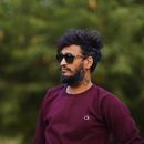 Stylish man with beard and sunglasses casually posing outdoors in Pune, India.
